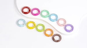 Macro shot of colorful rhinestone-studded round spring clasps for DIY accessories