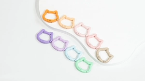 Cat-shaped spring snap hooks in macaron colors displayed on a white platform