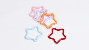 Close-up of star-shaped zinc alloy spring snap hooks in five vibrant assorted colors