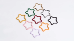 Detailed view of ten colorful star-shaped spring buckles in a vibrant metal finish