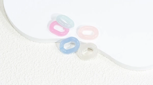 Dettaglio di anelli di catena in acrilico satinato color pastello per gioielli DIY