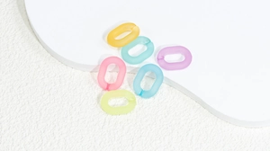 Dettaglio di anelli di catena in acrilico opaco in vari colori pastello per gioielli DIY