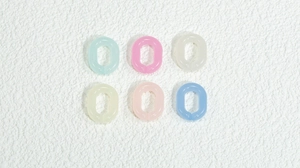 Dettaglio di anelli ovali in acrilico opaco in vari colori pastello per gioielli DIY