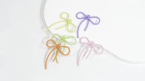 Detailopname van pastelkleurige strikhangertjes met textuur voor DIY-sieradenprojecten