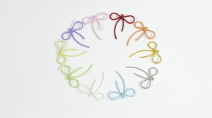Macro-opname van kleurrijke strikvormige hangers van legering met textuur voor DIY-sieraden
