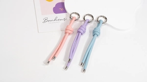 Close-up of pink, purple and blue leather keychain charms with silver metal rings