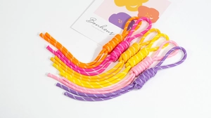 Detail of colorful hand-woven nylon zipper pulls and keychain cords in vibrant neon colors
