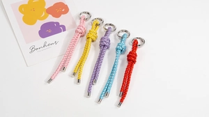 Close-up of five handmade colorful braided rope keychains with silver metal rings
