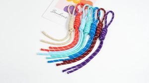 Detailed view of colorful handmade braided lanyards with decorative knots and loops