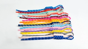 Detailed view of colorful hand-woven cords with reflective dots and decorative knots