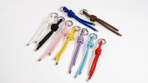 Close-up of handmade braided leather keychains in nine vibrant colors with metal rings