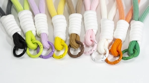 Macro detail of braided macaron cords with matching metal spring buckles and weave textures