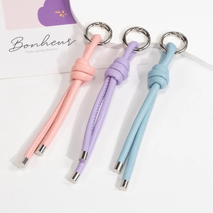 Handmade woven leather keychain set in pink, purple, and blue with silver rings