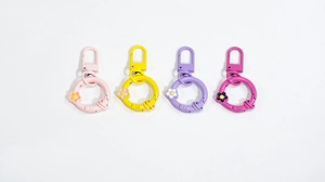 Detailed macro view of four colorful floral spring snap hooks and round key ring connectors