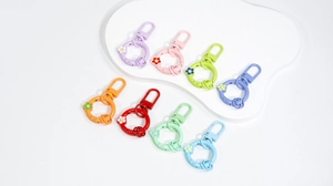 Flat lay of colorful flower spring keychains in eight matte candy colors for DIY projects