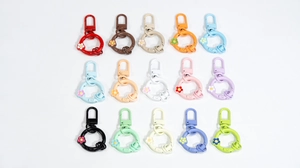 Flat lay of colorful flower-shaped spring ring buckles in fifteen assorted metal finishes
