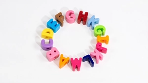 Dettaglio di perline colorate in acrilico con lettere disposte in cerchio per gioielli