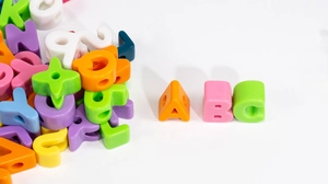 Dettaglio di perline colorate in acrilico con lettere e fori grandi per gioielli DIY