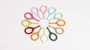 Flat lay of colorful alloy tennis racket spring buckles in twelve vibrant painted finishes