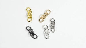 Dettaglio di anelli di collegamento in metallo a quattro maglie in oro e argento per gioielli DIY