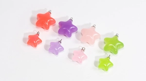 Détails macro de pendentifs étoiles en acrylique pastel avec boucles métalliques argentées