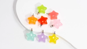 Vue macro de pendentifs étoiles colorés en acrylique translucide avec anneaux argentés