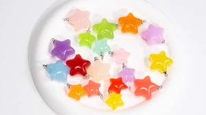 Gros plan de breloques étoiles colorées en acrylique aux couleurs gelées avec anneaux