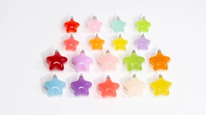Détail macro de dix-sept pendentifs étoiles colorés en acrylique avec anneaux en métal