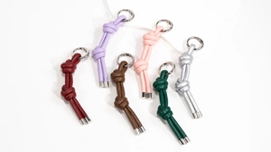 Dettaglio di portachiavi in pelle intrecciata colorata con anelli in metallo argento