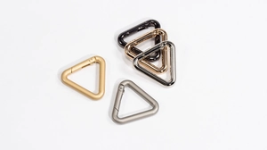 Close-up of triangle spring gate carabiners in various metallic finishes and colors