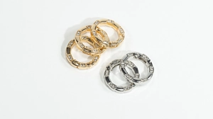 Detail of round spring snap rings with bamboo texture and sparkling inlaid rhinestones
