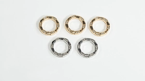 Macro detail of gold and silver bamboo-style spring rings with crystal pave for DIY