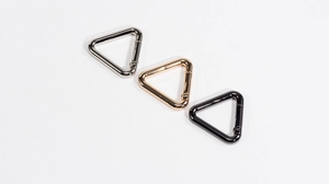 Detailed view of triangular spring snap hooks in silver, gold and black finishes