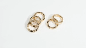Close-up of golden bamboo style spring rings with inlaid rhinestones for DIY jewelry