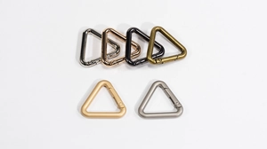 Detail view of triangular spring snap hooks in six diverse metallic finishes for bags