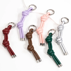 Portachiavi in pelle intrecciata in vari colori con anelli metallici su sfondo bianco