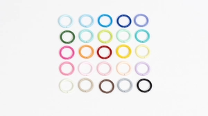 Macro shot of 25 colorful 10mm lacquered iron open rings in a 5x5 grid for DIY jewelry