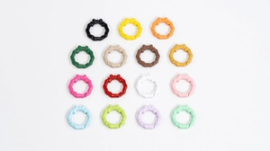 Macro view of 15 colorful spring ring keychains with bow detail and scalloped wavy edges