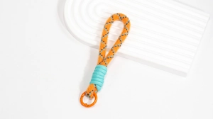 Nahaufnahme der orangefarbenen geflochtenen Handyschlaufe mit blauem Muster und Ring