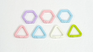 Primer plano de anillos de resorte metálicos hexagonales y triangulares en colores macaron