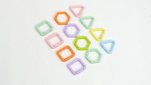 Vista macro de ganchos de anillo de resorte geométricos coloridos en formas cuadradas y hexagonales