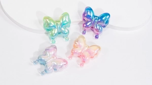 Macro shot of 4 iridescent gradient acrylic butterfly charms for DIY jewelry making