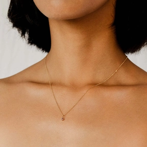 Elegante vergulde roestvrijstalen ketting met geboortesteen hanger om nek van een model