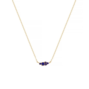 Close-up of golden O-chain necklace with five clustered dark blue gemstone pendants