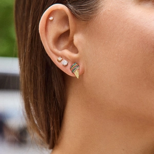 Detailopname van een kleurrijke strass ijsje oorbel en oorknopjes op een modeloor