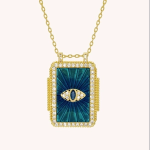 Macro view of gold tarot card pendant featuring blue evil eye and sparkling crystal border