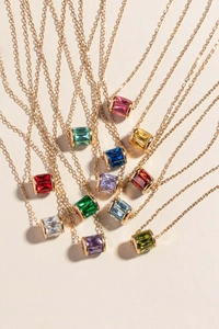 Macro shot of colorful birthstone barrel pendants on elegant gold chain necklaces