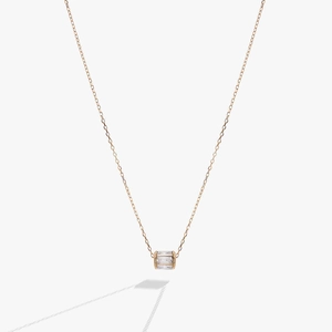 Macro detail of rose gold birthstone necklace featuring a cylindrical zircon pendant