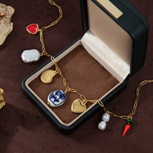 Bracelet doré bohème avec breloque cœur, perle, coquillage et pendentif piment rouge