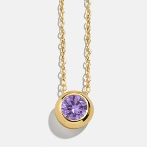 Detail of round purple birthstone pendant necklace with golden bezel setting and chain